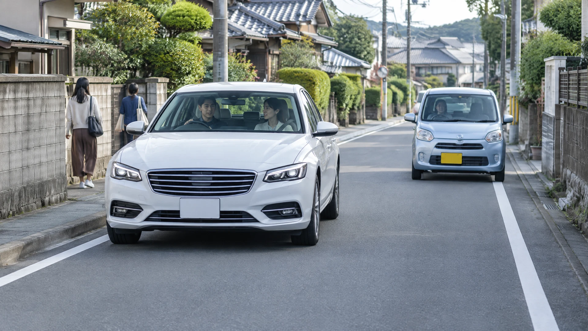 狭い住宅街で左ハンドルの外車がすれ違いを練習する様子