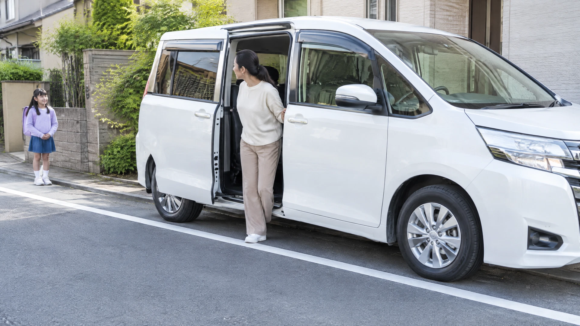 停車したミニバンのスライドドア周辺を確認する様子