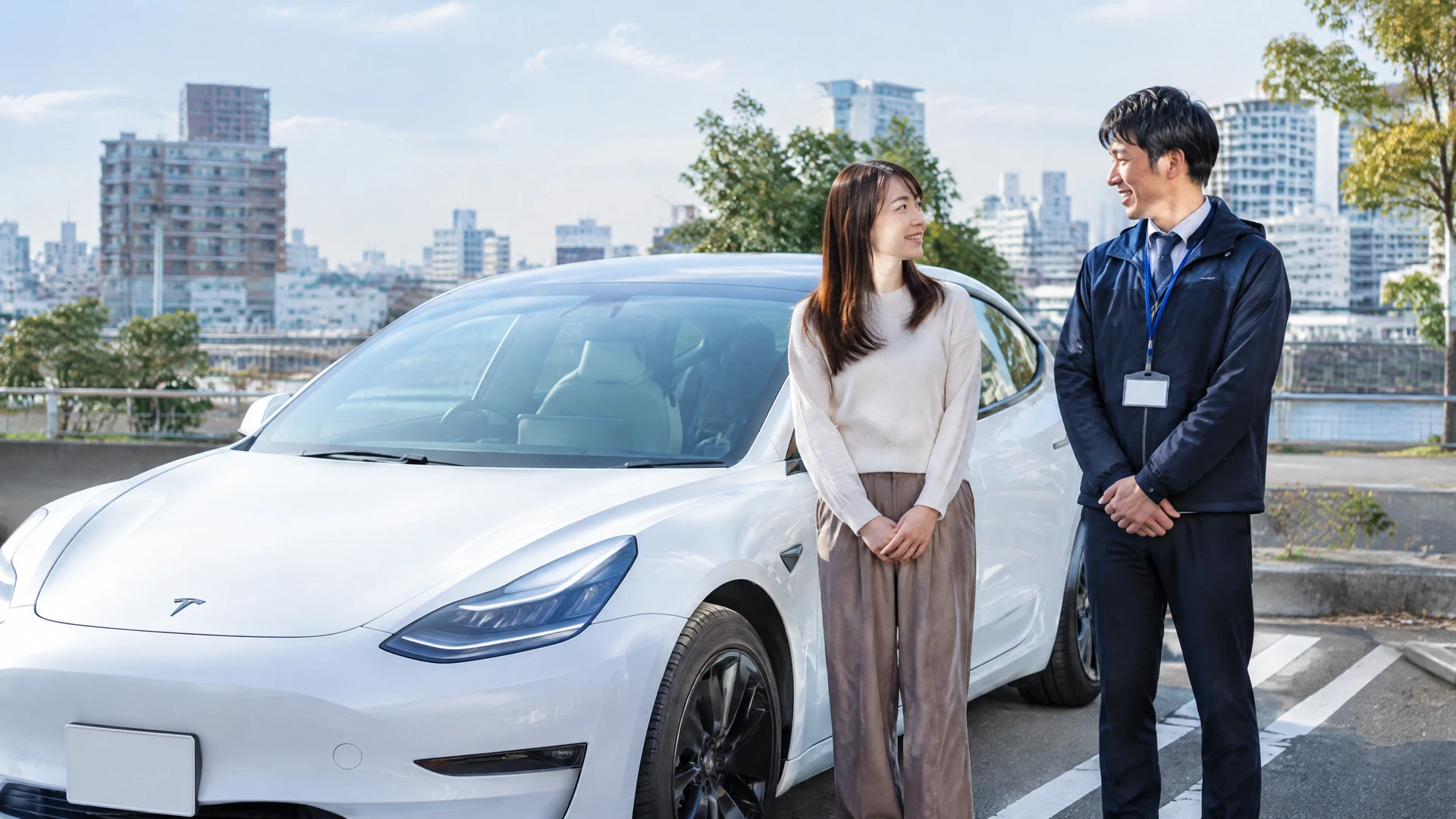 講習後、白いテスラ Model 3のそばに立つ受講者とインストラクター
