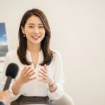 男性レポーターがマイクを持って女性タレントへインタビュー風景