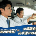 「新宿区西新宿を出発し、小滝橋交差点や山手通りでの車線変更を練習するペーパードライバー講習。運転席の男性が緊張した表情でハンドルを握り、隣のインストラクターが指示を出している。」