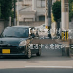 都内の狭い住宅街で交差点に差しかかる黒いコンパクトカー。ペーパードライバー向け危険シーン解説記事のアイキャッチ画像。